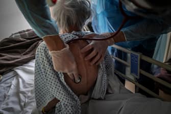 SENTHEIM, FRANCE- 3 APRIL 2020: (EDITORIAL USE ONLY) A doctor examines a coronavirus patient recovering at the Saint-Jean rehabilitation clinic on April 3, 2020 in Sentheim, France. By the beginning of April, France had more than 50,000 confirmed cases of COVID-19, with more than 4,000 related deaths. The country's Grand Est region, which includes the town of Mulhouse, has been particularly badly affected. The region became one of Europe's largest clusters of coronavirus cases after infected people attended a 2,500-person prayer meeting at a Mulhouse megachurch in February, well before the country imposed quarantine measures. (Photo by Veronique de Viguerie/Getty Images)