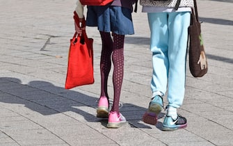 London, England, UK. Woman with very thin legs, walking with a friend