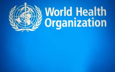 In this photo illustration, words that say Omicron COVID-19 variant is seen on a mobile phone screen in front of the WHO (World Health Organization) logo in the background. (Photo by Pavlo Gonchar / SOPA Images/Sipa USA)
