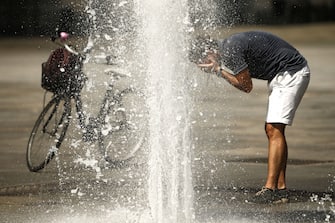 A man refreshes himself with the waters of a fountain at Piazza Castello in Turin on August 2, 2017, as they seek relief during a heatwave that continues to grip southern Europe. (Photo by Marco BERTORELLO / AFP)        (Photo credit should read MARCO BERTORELLO/AFP via Getty Images)