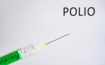 GERMANY - 2020/05/23: This photo illustration shows a disposable syringe with hypodermic needle, POLIO written on a white board behind. (Photo Illustration by Frank Bienewald/LightRocket via Getty Images)