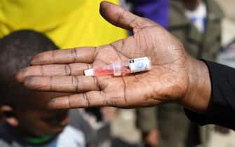 A community health worker shows a polio vaccine dose before delivering it to a child to fight against polio virus which is highly contagious and can cause paralysis and lifelong disability, or even death, during the polio immunization campaign in Kiamako, Nairobi on July 19, 2021. - Three million children across 13 counties of Kenya are to be vaccinated against polio by the Government, UNICEF, WHO and partners, after the virus was confirmed to be circulating. (Photo by SIMON MAINA / AFP) (Photo by SIMON MAINA/AFP via Getty Images)