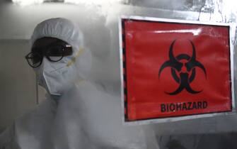 A technician wearing personal protective equipment (PPE) walks past a biohazard sign inside a molecular laboratory facility set up to test for the monkeypox disease during its inauguration at the King Institute in Chennai on July 28, 2022. (Photo by Arun SANKAR / AFP) (Photo by ARUN SANKAR/AFP via Getty Images)
