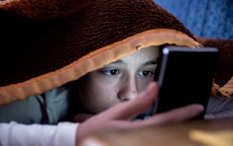 girl in bed texting on smartphone 
