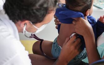 epa09630456 A doctor examines a child at the Flu Care Center, in the Alemao favela complex, in Rio de Janeiro, Brazil, 08 December 2021. The number of severe respiratory cases caused by influenza exceeds that of covid-19, according to information from the municipal Secretary of Health. Faced with this flu outbreak, which has already reached 20 thousand inhabitants of Rio de Janeiro, the city of Rio de Janeiro will receive 300 thousand doses of vaccine against the H3N2 influenza, from the Butantan Institute of Sao Paulo.  EPA/Andre Coelho