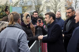 epa10355098 French President Emmanuel Macron (C) shakes hand with people as he arrives to attend a territorial session of the National Council for Refoundation on health (CNR) in Fontaine-le-Comte, near Poitiers, France 08 December 2022.  EPA/Teresa Suarez / POOL