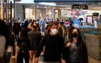 Persone con mascherine in un centro commerciale