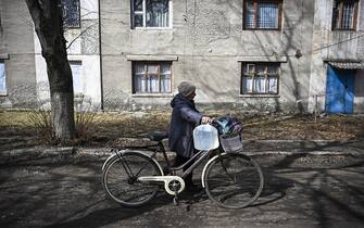 CHASIV YAR, UKRAINE - MARCH 17: A woman walks home after filling water jugs as daily life continues under difficult conditions amid Russia-Ukraine war in Chasiv Yar, Ukraine on March 17, 2023. (Photo by Muhammed Enes Yildirim/Anadolu Agency via Getty Images)