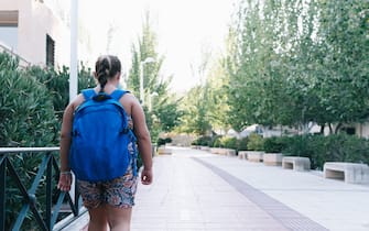 Obese Blonde girl with blue backpack on her way to school