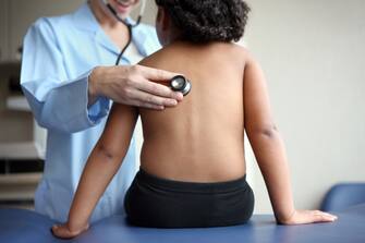 145897369 A female pediatrician listens to a three-year-old girl's lungs with a stethoscope.