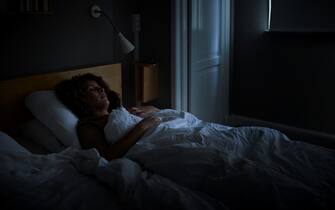 Mature woman sleeping on bed at home