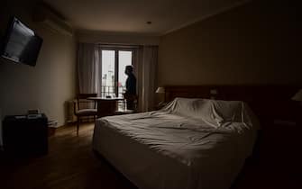 BUENOS AIRES, ARGENTINA - JULY 01: Daniel Muñoz, owner of Bristol Hotel, looks to the Obelisk trough the window of and empty room  during the lockdown on July 01, 2020 in Buenos Aires, Argentina. In April, the activity in hotels dropped up to 85%, due to travel and circulation restrictions to halt coronavirus spread. Some places host patients with COVID-19 after an agreement with local authorities and some remain closed. According to the national statistics bureau (INDEC), economy in Argentina shrank 26% year on year in April, the first full month of coronavirus lockdown. Due to increasing number of cases in Buenos Aires Aires metropolitan, authorities tightened restrictions allowing only essential shops and industries to remain open to public. Apart from dealing with the pandemic, Argentina is on default and holds a negotiation with creditors to restructure a 66 billion USD debt. (Photo by Amilcar Orfali/Getty Images)