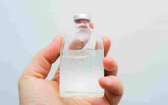 vial with transparent drug solution in a man's hand