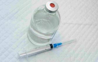 vial with clear drug solution and a syringe
