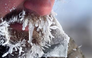 Extremely severe frosts cover people with icicles. Cold weather and climate change in winter. Person suffers from hypothermia. Unusually harsh winter