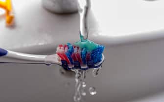 Toothbrush with toothpaste and water from the faucet