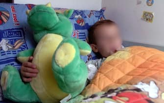 Un bambino a letto sotto le coperte