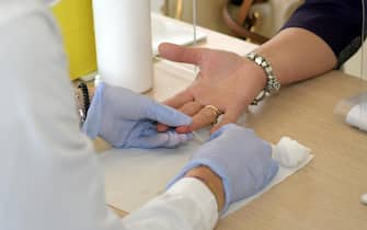 Un'addetta sanitaria effettua un test sierologici a una residente del Comune di Carpiano,  09 Giugno 2020. I cittadini hanno iniziato a sottoporsi allo screening. Ansa/Andrea Canali.
