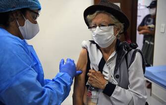 A medical worker applies a flu vaccine to an elderly woman in Asuncion, on, April 15, 2020 during the coronavirus COVID-19 pandemic. - Health authorities in Paraguay are encouraging people over 60 to be vaccinated against the flu, also a respiratory disease, to reduce complications of those who might contact the new coronavirus. (Photo by Norberto DUARTE / AFP) (Photo by NORBERTO DUARTE/AFP via Getty Images)