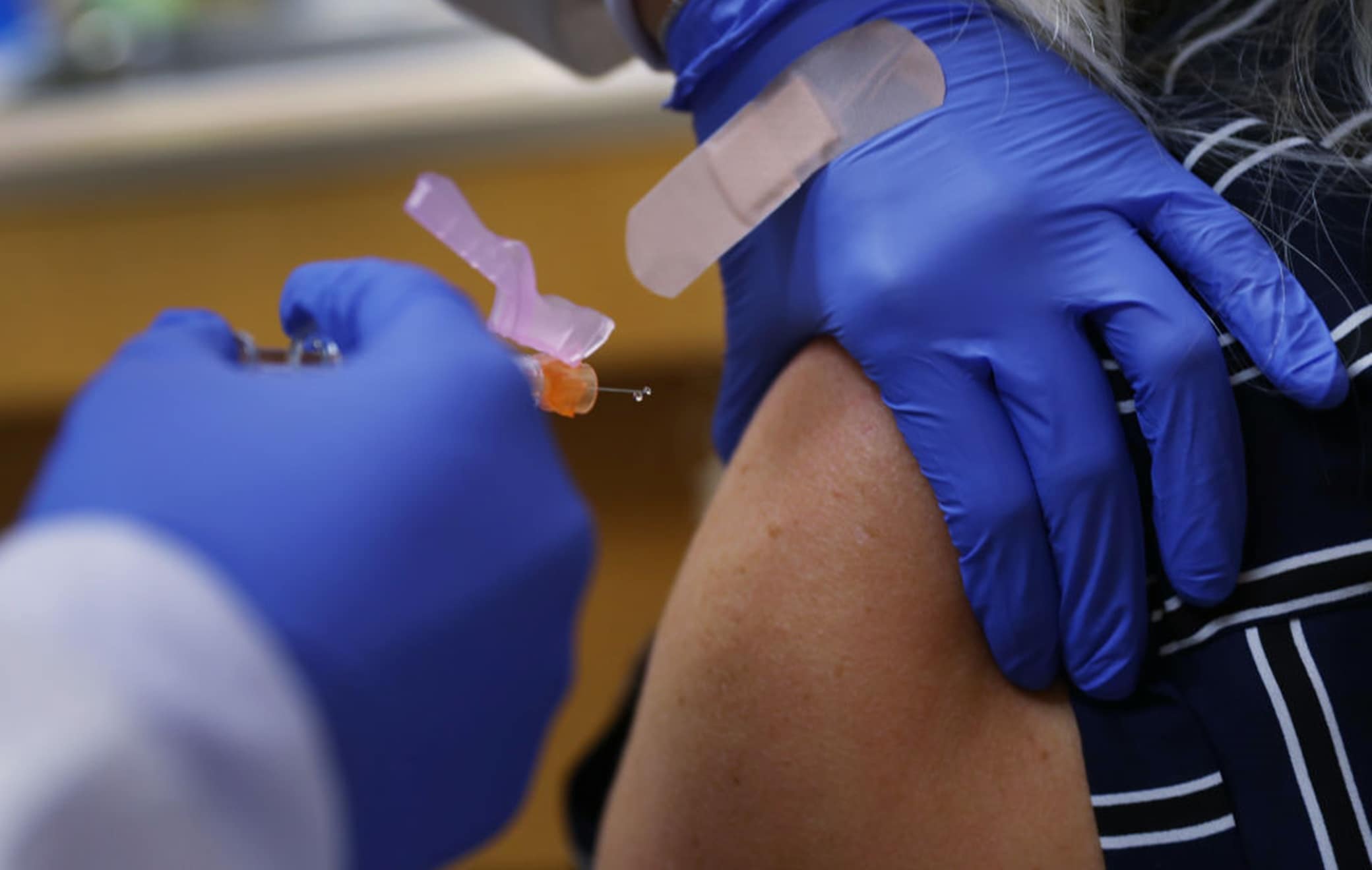 1270517912 KEY BISCAYNE, FLORIDA - SEPTEMBER 03: Enbal Sabag, a Nurse Practitioner, wears personal protection equipment as she administers a flu vaccination to Noel Janzen at the CVS pharmacy and MinuteClinic on September 03, 2020 in Key Biscayne, Florida. Flu shots are available at the nearly 10,000 CVS pharmacies and approximately 100 MinuteClinic locations across the country. Heath experts say getting the flu shot this year is important because the dangers of having COVID-19 and the flu simultaneously are still unknown. (Photo by Joe Raedle/Getty Images)
