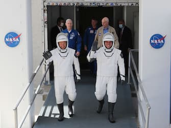 CAPE CANAVERAL, FLORIDA - MAY 30: NASA astronauts Bob Behnken (R) and Doug Hurley walk out of the Operations and Checkout Building on their way to the SpaceX Falcon 9 rocket with the Crew Dragon spacecraft on launch pad 39A at the Kennedy Space Center on May 30, 2020 in Cape Canaveral, Florida. The inaugural flight will be the first manned mission since the end of the Space Shuttle program in 2011 to be launched into space from the United States. (Photo by Joe Raedle/Getty Images)