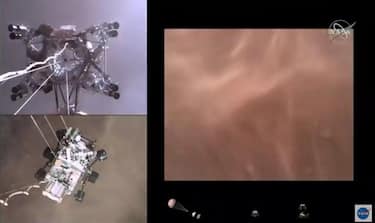 La Nasa ha pubblicato un video spettacolare dell'atterraggio del suo rover Perseverance, il primo del genere, dopo l'arrivo della missione su Marte. La
clip, lunga poco più di tre minuti, svela le immagini di più telecamere situate in differenti posizioni, dopo l'entrata della sonda nell'atmosfera del pianeta rosso: una mostra il dispiegamento del paracadute supersonico, un'altra - sotto la sonda - il suolo di Marte che si avvicina e altre due il rover che tocca terra, appeso a tre cavi. Durante la vertiginosa discesa non è stato tuttavia registrato alcun suono. ANSA/NASA +++ NO SALES, EDITORIAL USE ONLY +++