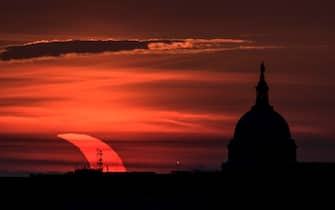 epa09259308 A handout picture made available by the National Aeronautics and Space Administration (NASA) shows a partial solar eclipse as the sun rises to the left of the United States Capitol Building, 10 June 2021, as seen from Arlington, Virginia. The annular or  ring of fire  solar eclipse is only visible to some people in Greenland, Northern Russia, and Canada.  EPA/NASA HANDOUT / Bill Ingalls  HANDOUT EDITORIAL USE ONLY/NO SALES