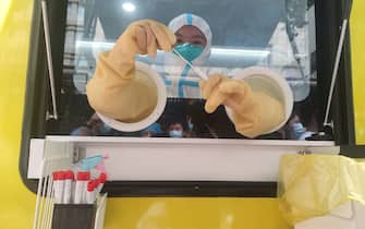 WUHAN, CHINA - AUGUST 05: A medical worker is seen in a mobile COVID-19 nucleic acid testing laboratory on August 5, 2021 in Wuhan, Hubei Province of China. (Photo by Zheng Ziyan/China News Service via Getty Images)