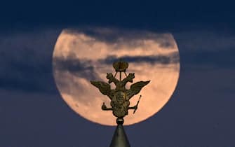 The full moon also known as Flower blood moon is pictured behind the two-headed eagle, the national symbol of Russia atop a building on Red Square in downtown Moscow on May 15, 2022. (Photo by Kirill KUDRYAVTSEV / AFP) (Photo by KIRILL KUDRYAVTSEV / AFP via Getty Images)