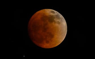 The blood moon is seen during a total lunar eclipse in Panama City on May 15, 2022. (Photo by Luis ACOSTA / AFP) (Photo by LUIS ACOSTA / AFP via Getty Images)