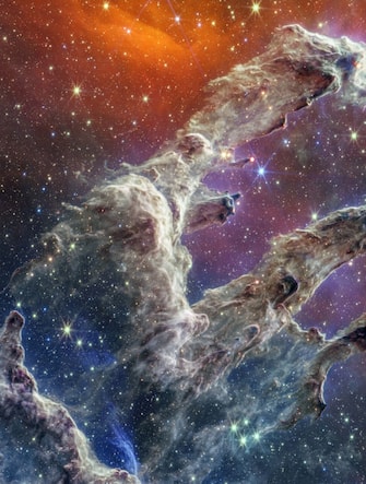 By combining images of the iconic Pillars of Creation from two cameras aboard NASA’s James Webb Space Telescope, the universe has been framed in its infrared glory. Webb’s near-infrared image was fused with its mid-infrared image, setting this star-forming region ablaze with new details.

 

Myriad stars are spread throughout the scene. The stars primarily show up in near-infrared light, marking a contribution of Webb’s Near-Infrared Camera (NIRCam). Near-infrared light also reveals thousands of newly formed stars – look for bright orange spheres that lie just outside the dusty pillars.

 

In mid-infrared light, the dust is on full display. The contributions from Webb’s Mid-Infrared Instrument (MIRI) are most apparent in the layers of diffuse, orange dust that drape the top of the image, relaxing into a V. The densest regions of dust are cast in deep indigo hues, obscuring our view of the activities inside the dense pillars.

 

Dust also makes up the spire-like pillars that extend from the bottom left to the top right. This is one of the reasons why the region is overflowing with stars – dust is a major ingredient of star formation. When knots of gas and dust with sufficient mass form in the pillars, they begin to collapse under their own gravitational attraction, slowly heat up, and eventually form new stars. Newly formed stars are especially apparent at the edges of the top two pillars – they are practically bursting onto the scene.

 

At the top edge of the second pillar, undulating detail in red hints at even more embedded stars. These are even younger, and are quite active as they form. The lava-like regions capture their periodic ejections. As stars form, they periodically send out supersonic jets that can interact within clouds of material, like these thick pillars of gas and dust. These young stars are estimated to be only a few hundred thousand years old, and will continue to form for millions of years.

 

Almost everything you see in this scene is local. The distant universe is largely blocked from our view both by the interstellar medium, which is made up of sparse gas and dust located between the stars, and a thick dust lane in our Milky Way galaxy. As a result, the stars take center stage in Webb’s view of the Pillars of Creation.

 

The Pillars of Creation is a small region within the vast Eagle Nebula, which lies 6,500 light-years away.

 

NIRCam was built by a team at the University of Arizona and Lockheed Martin’s Advanced Technology Center.

 

MIRI was contributed by ESA and NASA, with the instrument designed and built by a consortium of nationally funded European Institutes (The MIRI European Consortium) in partnership with JPL and the University of Arizona.

Where: United States
When: 02 Dec 2022
Credit: NASA/ESA/CSA/STScI/Cover Images

**EDITORIAL USE ONLY. MATERIALS ONLY TO BE USED IN CONJUNCTION WITH EDITORIAL STORY. THE USE OF THESE MATERIALS FOR ADVERTISING, MARKETING OR ANY OTHER COMMERCIAL PURPOSE IS STRICTLY PROHIBITED. MATERIAL COPYRIGHT REMAINS WITH STATED SUPPLIER.**

-PICTURED: Pillars Of Creation
-LOCATION:  UK
-DATE: 2 Dec 2022
-CREDIT: NASA/ESA/CSA/STScI/Cover Images/INSTARimages.com