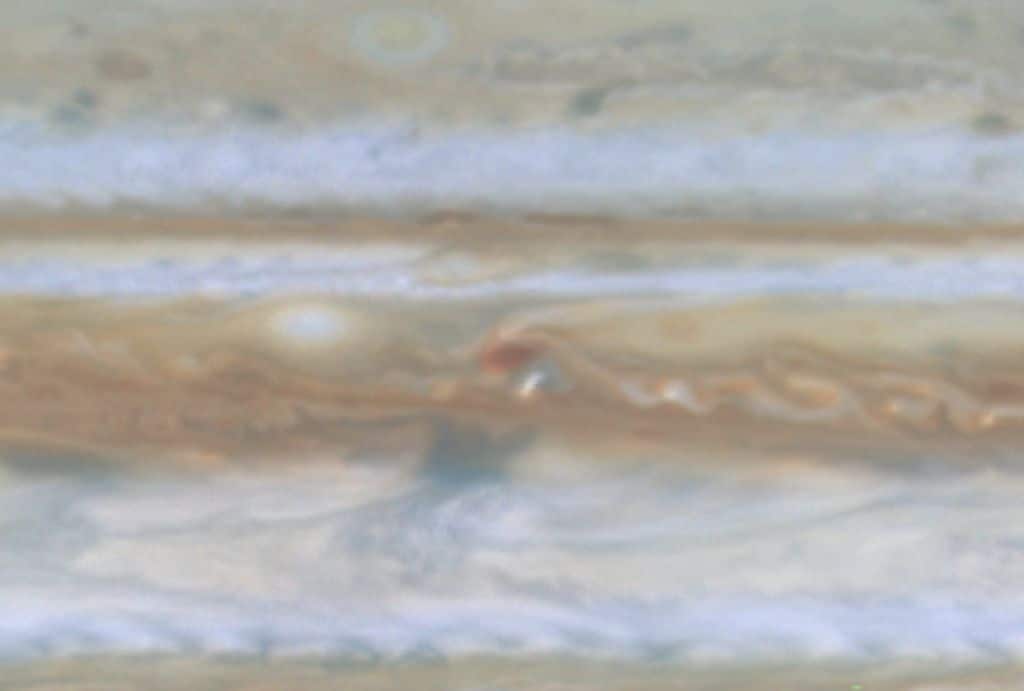 Nella foto di Giove ripresa dalla sonda spaziale Cassini, la piccola macchia bianca è probabilmente un temporale fulmine giove