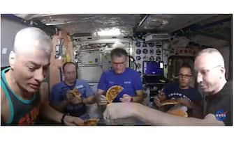 Nespoli e altri astronauti mangiano una pizza