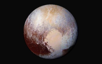 (FILE) SPACE PLUTO DEMOTION ANNIVERSARY epa06940540 (FILE) - A handout image provided by the National Aeronautics and Space Administration (NASA) on 24 July 2015 shows the dwarf planet Pluto in enhanced color. Scientists used enhanced color images of the New Horizons probe to detect differences in the composition and texture of Pluto's surface. Four images from New Horizons' Long Range Reconnaissance Imager (LORRI) were combined with color data from the Ralph instrument to create this enhanced color global view from a distance of 280,000 miles (450,000 kilometers). Discovered on 18 February 1930 and for a long time considered the ninth and most distant planet to the sun in our solar system, it was reclassified as a 'dwarf planet' by the International Astronomical Union (IAU) on 24 August 2006 after another dwarft planet with a 27 percent bigger mass than Pluto was discovered in the so-called Kuiper belt beyond the planet Neptune. *** Local Caption *** 52653960 EPA/NASA/JHUAPL/SwRI/HANDOUT MANDATORY CREDIT: NASA/JHUAPL/SwRI HANDOUT EDITORIAL USE ONLY *** Local Caption *** 52653960