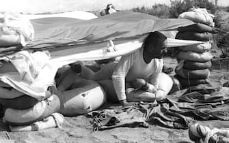 19th August 1963:  American astronaut Neil Armstrong peers from a makeshift tent in Nevada during an intensive three day desert training course for future space travellers. He later became the first man on the moon.  (Photo by Keystone/Getty Images)