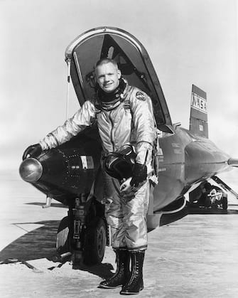 1966:  Full-length portrait of American astronaut Neil Armstrong, wearing a NASA spacesuit, smiling while standing with his hand on the 'hot nose' of an X-15 shuttle on a tarmac. The 'hot nose' is an invention which senses the X-15's alitude angles and compensates to lessen the frictional heat during the exit and re-entry phases of hypersonic flight in the upper atmoshere.  (Photo by Hulton Archive/Getty Images)