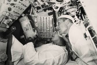 (Original Caption) Before the Launch. Space Center, Houston: Gemini 8 astronauts Neil Armstrong (right) and David Scott headed for Okinawa aboard a destroyer to help puzzled scientists learn why their space machine suddenly turned into a potential death trap. The astronauts are seen here studying the interior of the spacecraft at Cape Kennedy prior to the March 16 launch.