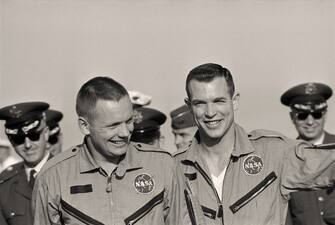 (Original Caption) Happy Duo. Cape Kennedy: Smiling Happily, Gemini-8 astronauts Neil Armstrong (left) and David Scott greet their colleagues after they arrived at Cape Kennedy. The pilots were taken to the Cape by the USS Mason after they were picked up in the Pacific following their aborted mission.