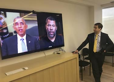 Paul Scharre views in his offices in Washington, DC January 25, 2019 a manipulated video by BuzzFeed with filmmaker Jordan Peele (R on screen) using readily available software and applications to change what is said by former president Barack Obama (L on screen), illustrating how deepfake technology can deceive viewers. - "Deepfake" videos that manipulate reality are becoming more sophisticated and realistic as a result of advances in artificial intelligence, creating a potential for new kinds of misinformation with devastating consequences. (Photo by Robert LEVER / AFP) / TO GO WITH AFP STORY by Rob LEVER "Misinformation woes may multiply with deepfake videos"        (Photo credit should read ROBERT LEVER/AFP via Getty Images)