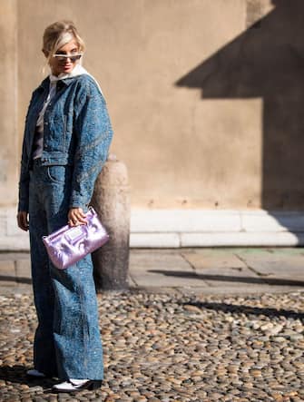 MILAN, ITALY - FEBRUARY 22: Xenia Adonts, wearing a purple Maison Margiela bag and denim jacket and pants, is seen outside Etro on Day 3 Milan Fashion Week Autumn/Winter 2019/20 on February 22, 2019 in Milan, Italy. (Photo by Claudio Lavenia/Getty Images)