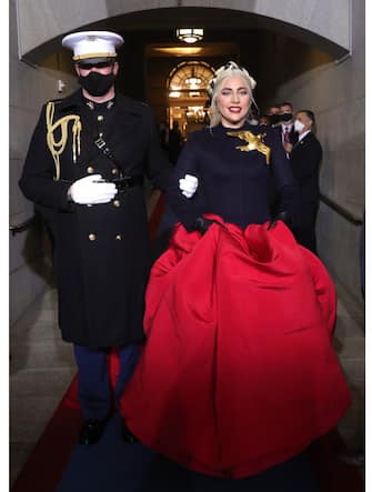 WASHINGTON, DC - JANUARY 20: Lady Gaga is escorted by U.S. Marine escort Capt. Evan Campbell to sing the National Anthem at the inauguration of U.S. President-elect Joe Biden on the West Front of the U.S. Capitol on January 20, 2021 in Washington, DC.  During todayâ  s inauguration ceremony Joe Biden becomes the 46th president of the United States. (Photo by Win McNamee/Getty Images)