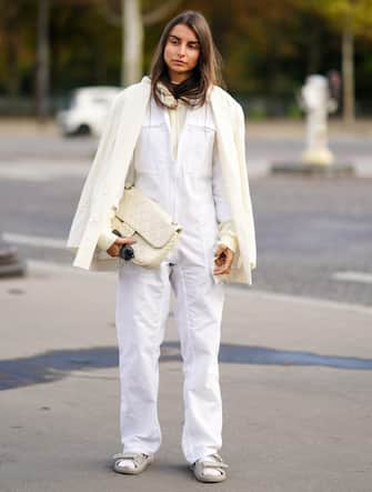 PARIS, FRANCE - OCTOBER 06: A guest wears a white jacket, a white jumpsuit, a white quilted Chanel bag, Chanel padded sandals, outside Chanel, during Paris Fashion Week - Womenswear Spring Summer 2021, on October 06, 2020 in Paris, France. (Photo by Edward Berthelot/Getty Images)