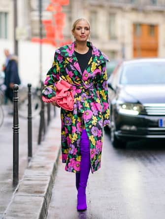 PARIS, FRANCE - FEBRUARY 25: Leonie Hanne wears earrings, a black top, a Givenchy pink bag, a Balenciaga trench coat with colorful flowers print, purple thigh-high sock-boots, during Paris Fashion Week - Womenswear Fall/Winter 2020/2021, on February 25, 2020 in Paris, France. (Photo by Edward Berthelot/Getty Images)