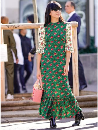 PARIS, FRANCE - SEPTEMBER 26:  A guest wears a green pleated dress with printed flowers and red roses, during Paris Fashion Week Womenswear Spring/Summer 2019, on September 26, 2018 in Paris, France.  (Photo by Edward Berthelot/Getty Images)