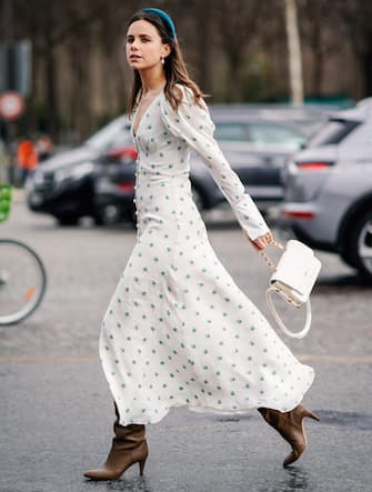 PARIS, FRANCE - MARCH 05: A guest wears a headband, a white dress with printed blue flowers, a white Chanel bag, outside Chanel, during Paris Fashion Week Womenswear Fall/Winter 2019/2020, on March 05, 2019 in Paris, France. (Photo by Edward Berthelot/Getty Images)