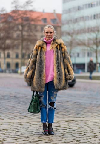 633607636 COPENHAGEN, DENMARK - FEBRUARY 02: Lena-Sophie Krups wearing a fur jacket, ripped denim jeans, green Balenciaga bag, pink knit, Gucci shoes during the Copenhagen Fashion Week Autumn/Winter 17 on February 2, 2017 in Copenhagen, Denmark. (Photo by Christian Vierig/Getty Images)