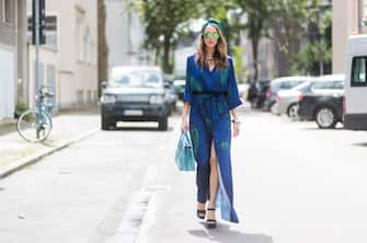 DUESSELDORF, GERMANY - AUGUST 4: Model and fashion blogger Alexandra Lapp wearing a blue Kimono maxi dress with green leaf print from Borgo de Nor, green metallic Aviator sunglasses by Ray-Ban, plateau heels from Prada, Milla MCM bag in turquoise, a green bandana turban, neck ripe and bracelet in grey gold by Schubart Goldschmiede, three rings in grey gold with a green Tourmaline by Schubart on August 4, 2017 in Duesseldorf, Germany. (Photo by Christian Vierig/Getty Images)