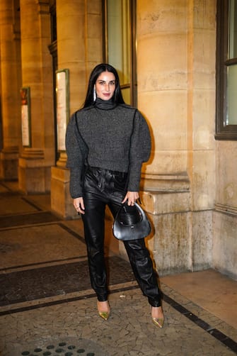 PARIS, FRANCE - OCTOBER 01: Fiona Zanetti wears long bejeweled earrings, a gray turtleneck oversized wool pullover with puff sleeves, black leather pants, a black leather Coperni bag, golden shiny pointy shoes, outside Isabel Marant, during Paris Fashion Week - Womenswear Spring Summer 2021, on October 01, 2020 in Paris, France. (Photo by Edward Berthelot/Getty Images)