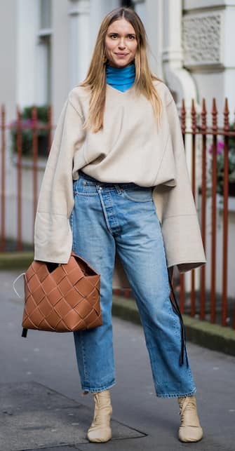 919114552 LONDON, ENGLAND - FEBRUARY 16: Pernille Teisbaek wearing denim jeans blue turtleneck, creme white sweater with long sleeves seen, brown bag outside Mulberry during London Fashion Week February 2018 on February 16, 2018 in London, England. (Photo by Christian Vierig/Getty Images)