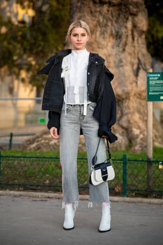 PARIS, FRANCE - JANUARY 19: Caro Daur, wearing a white shirt, black denim jacket, grey jeans and black, white boots and white Prada bag, is seen in the streets of Paris before the Sacai show on January 19, 2019 in Paris, France. (Photo by Claudio Lavenia/Getty Images)